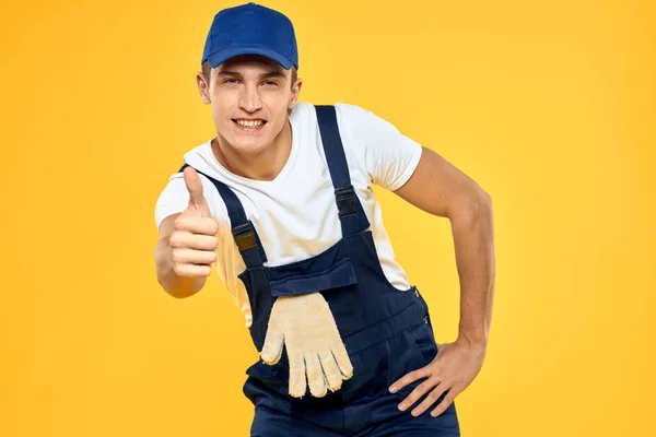 手袋レンダリングサービスの制服を着た働く男黄色の背景 — ストック写真