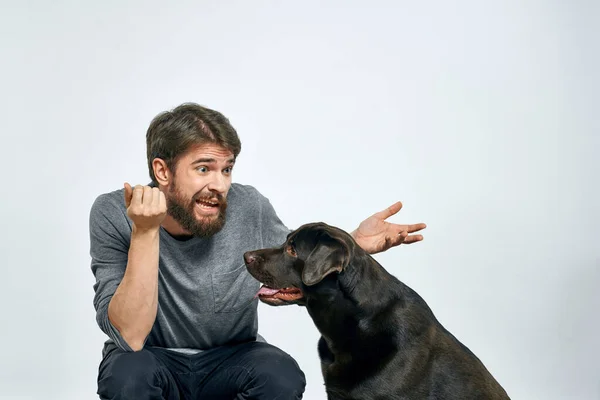 Feliz propietario con mascota negro perro entrenamiento modelo emociones — Foto de Stock