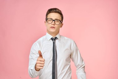 Beyaz gömlekli, kravatlı, gözlüklü, kendine güvenen, resmi pembe arka planlı bir iş adamı.