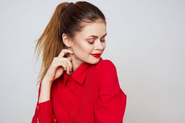 Açık arkaplanda kırmızı dudaklı bir kadının portresi. Makyaj modeli.