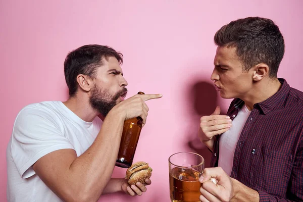 Deux hommes boivent de la bière amitié ivre alcool style de vie rose fond — Photo