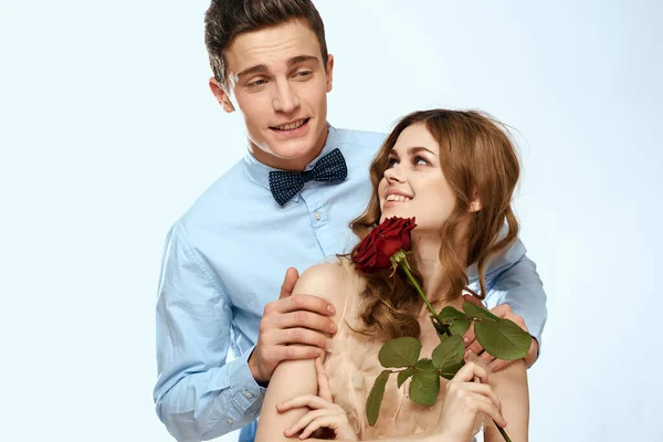 Homem e mulher com uma rosa vermelha em um fundo leve amor abraços familiares — Fotografia de Stock