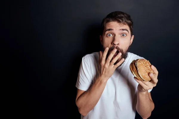 Man eating hamburger fast food restaurant Gourmet eating dark background