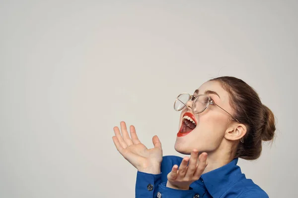Porträt einer emotionalen Frau in blauem Hemd und Brille helles Make-up Modell Licht Hintergrund abgeschnitten Ansicht kopieren Raum — Stockfoto
