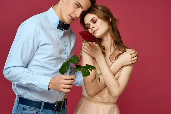 Retrato de pareja romántica enamorada de rosa roja sobre fondo aislado y traje clásico vestido de noche — Foto de Stock