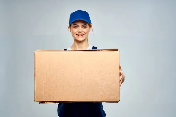 Женщина в рабочей форме с коробкой в руках службы доставки светлый фон — стоковое фото