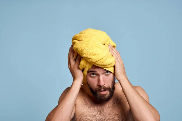 Man met gele handdoek op hoofd heldere huid kale schouders blauwe achtergrond — Stockfoto