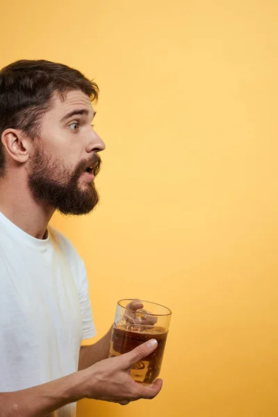 Homem com uma caneca de cerveja divertido álcool estilo de vida branco t-shirt amarelo isolado fundo — Fotografia de Stock