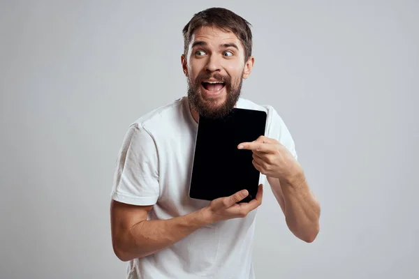 Hombre emocional con la tableta en la pantalla táctil de la mano nuevas tecnologías luz fondo recortado vista Copiar espacio —  Fotos de Stock