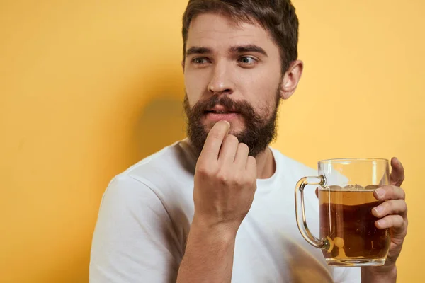 Homme avec une tasse de bière fun alcool style de vie blanc t-shirt jaune fond isolé — Photo