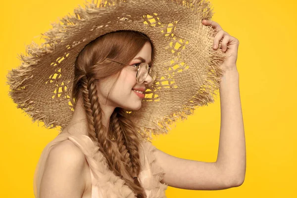 Retrato de uma mulher bonita com tranças e com um chapéu na cabeça em um fundo amarelo vista cortada — Fotografia de Stock