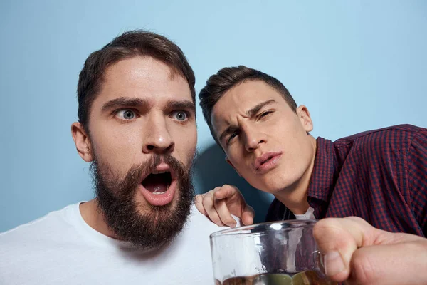 Deux amis ivres joyeux buvant de la bière mode de vie émotions sur un fond bleu — Photo