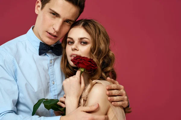 Retrato de pareja romántica enamorada de rosa roja sobre fondo aislado y traje clásico vestido de noche — Foto de Stock
