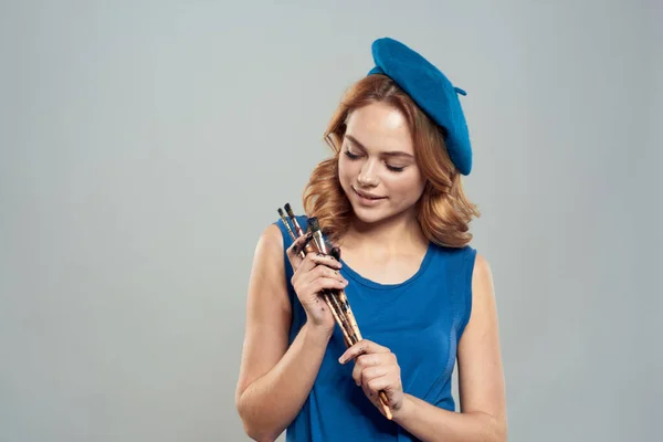 Frau Künstler Pinsel in der Hand blaue Baskenmütze Kleid Hobby Kunst Lifestyle Licht Hintergrund — Stockfoto