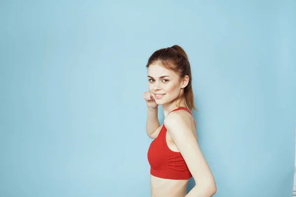 Sportieve vrouw rood tank top workout levensstijl gym blauw achtergrond — Stockfoto