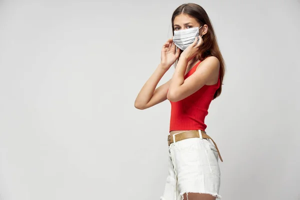 Nő védő maszkot ellen coronavirus pózol stúdióban. — Stock Fotó