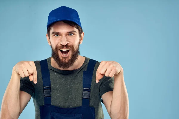 Man in werk uniform uniform professioneel werk levensstijl bezorgservice blauwe achtergrond — Stockfoto