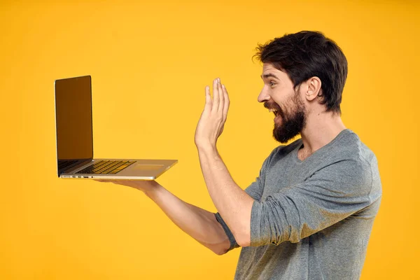 Человек с ноутбуком беспроводной технологии Интернет стиль жизни работать желтый изолированный фон — стоковое фото