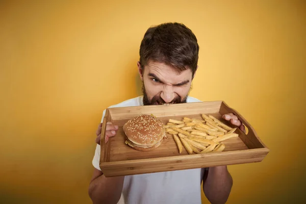 木製パレット付きの男ファーストフードハンバーガーフランス語フライドポテト食事摂取量クローズアップ — ストック写真
