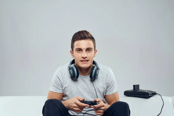 Man zit op de bank hoofdtelefoon joystick games entertainment verslaving vrijetijdsbesteding technologie — Stockfoto