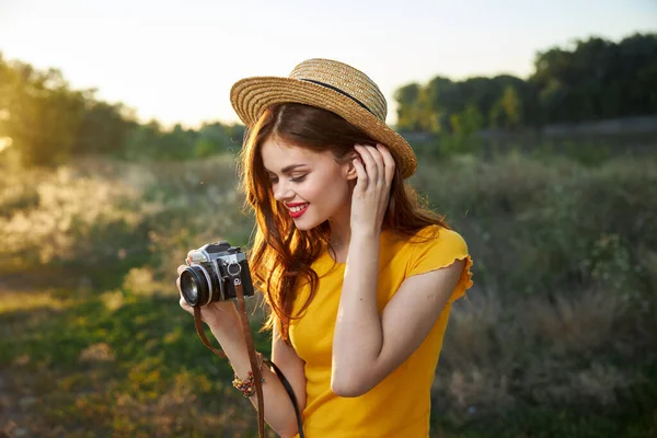 Wanita memegang kamera di tangannya topi meluruskan senyum rambutnya bibir merah alam — Stok Foto