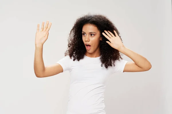 Mulher com cabelo encaracolado preto em uma t-shirt gesticular com as emoções da mão — Fotografia de Stock