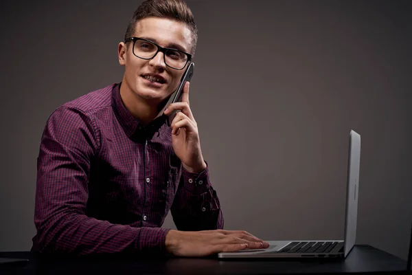 Gerente do sexo masculino está sentado à mesa e falando no telefone aberto laptop trabalhando sala de escritório — Fotografia de Stock