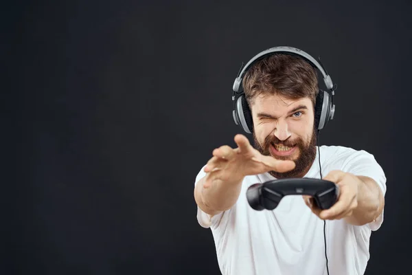 Man in hoofdtelefoon met gamepad leuke entertainment games lifestyle donkere achtergrond — Stockfoto