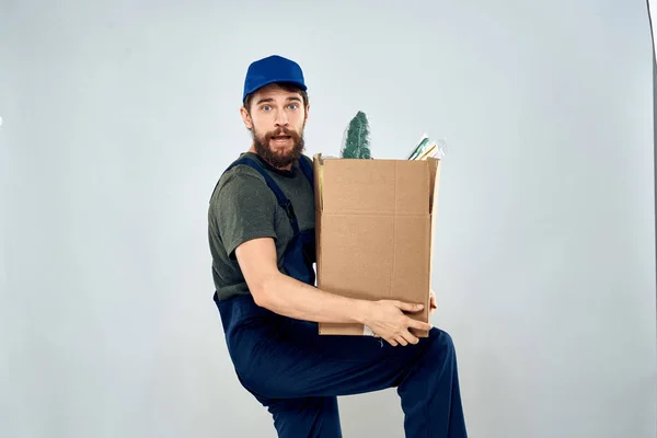 Mężczyzna w mundurze roboczym z pudełkami w rękach załadunek styl życia — Zdjęcie stockowe