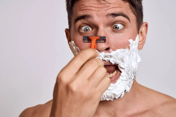 Snygg man med vitt raklödder i ansiktet och ren hud med rakhyvel grooming bara axlar — Stockfoto