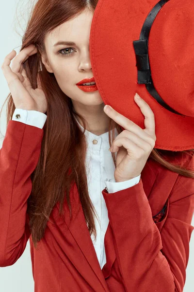 긴 머리를 하고 있는 빨간 재킷 모자를 쓴 고상 한 여자가 밝은 배경을 도려냈다 — 스톡 사진