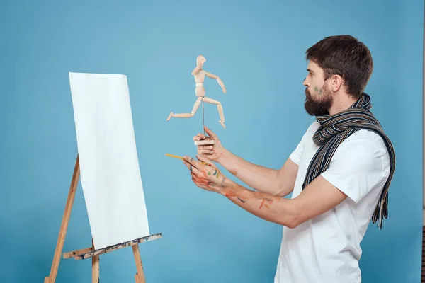 Maschio artista con un manichino di legno in mano disegno Creativo hobby sfondo blu — Foto Stock