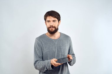 Gri kazaklı bir adam duyguların elinde bir tablet İnternet teknolojisi yaşam tarzı hafif arka plan