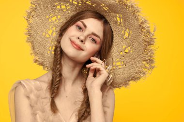 Şapkalı ve elbiseli bir bayan. Kızıl saçlı, sarı arka planlı, model portresi eğlenceli.