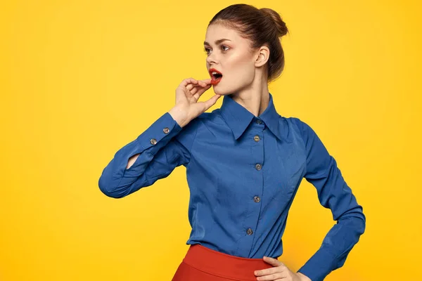 Aantrekkelijke vrouw in blauw shirt gebaren met haar handen en rode rok gele achtergrond portret bijgesneden uitzicht — Stockfoto