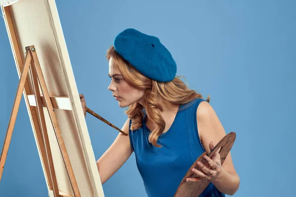 Kadın sanatçı mavi bereli palet çizim sehpası yaratıcılık mavi arka plan — Stok fotoğraf