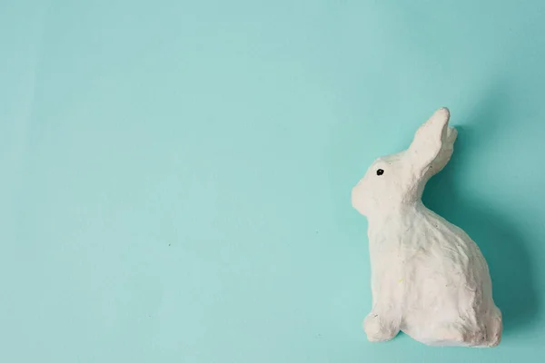 Festliche weiße Hasenspielzeug auf blauem Hintergrund mit Pastellfarben Ostern — Stockfoto
