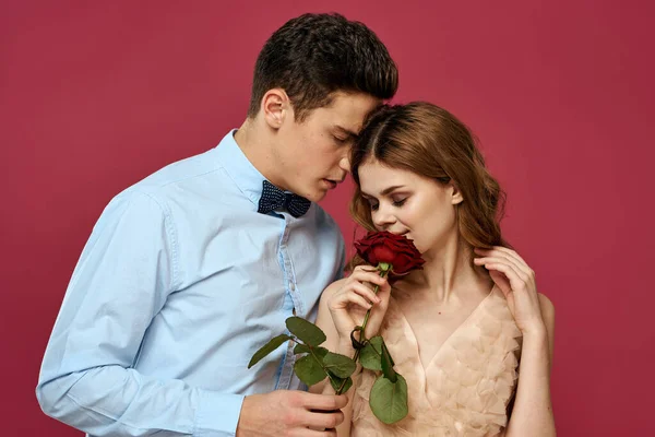 Retrato de casal romântico apaixonado por rosa vermelha em fundo isolado e vestido de noite terno clássico — Fotografia de Stock