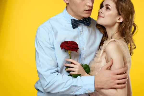 Förälskad man och kvinna med röd ros på gul bakgrund beskärd vy närbild romantik — Stockfoto