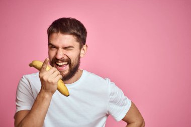 Elinde muz olan sakallı adam pembe arka planda eğlenceli duygu modeli