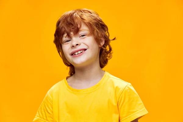 Rödhårig pojke skrattar in i kameran och uttrycksfullt utseende — Stockfoto