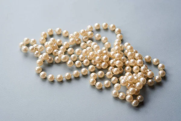 Pearl beads on a gray background decoration decoration top view — Stock Photo, Image