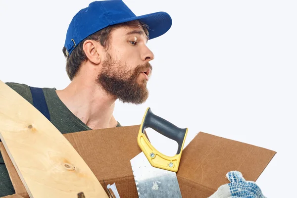 Trabajador hombre en uniforme con una caja en sus manos herramientas entrega servicio luz fondo — Foto de Stock