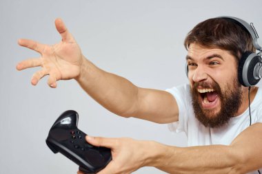 Gamepad 'li kulaklıklı bir adam hobi hayatı tarzı hafif arka planda oynuyor.