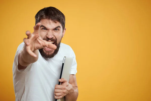 emotional man with laptop on yellow background gesturing with hands cropped view Copy Space