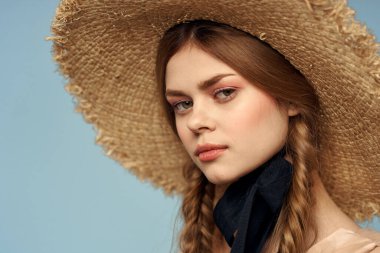 Hasır şapkalı kız portresi yakın çekim at kuyruğu eğlenceli kızıl saçlı mavi arka plan