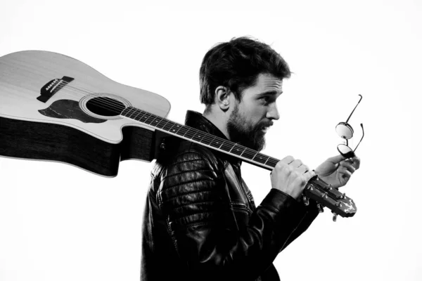 Elinde gitar tutan bir adam. Müzik duyguları. Siyah deri ceket. — Stok fotoğraf