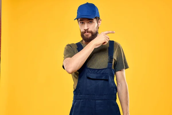 Man in werk uniform rendering dienst vorkheftruck werk levensstijl gele achtergrond — Stockfoto