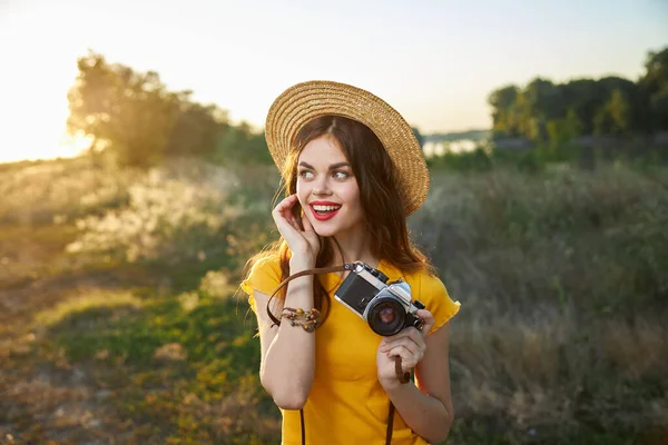 Wanita cantik dengan kamera di tangannya di alam terlihat pada sisi senyum bibir merah musim panas — Stok Foto