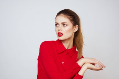 Açık arkaplanda kırmızı dudaklı bir kadının portresi. Makyaj modeli.